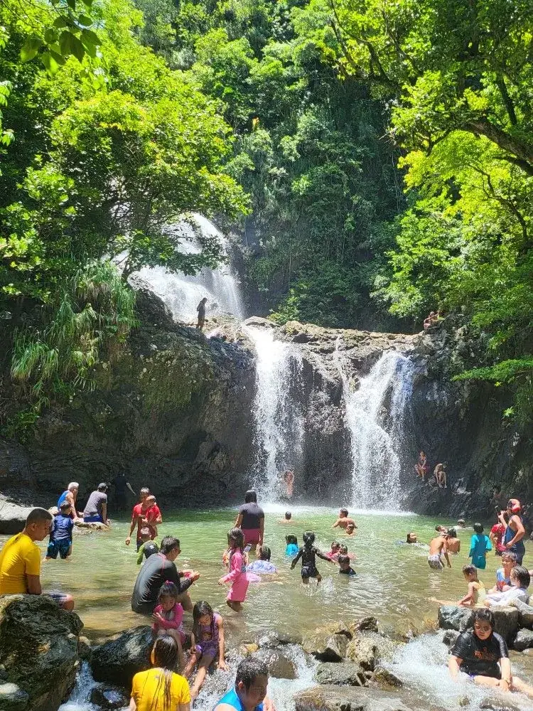 Visitantes se bañan en una poza al pie de una cascada, entre la selva