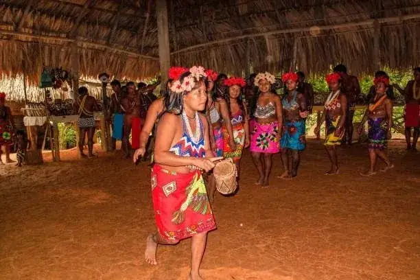 Mujeres emberá bailan bajo un techo de palma