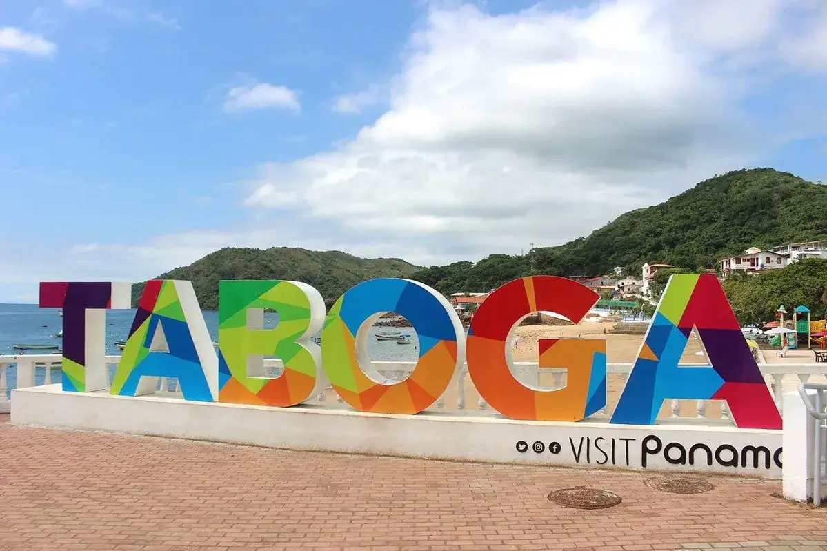 El letrero de colores de Taboga, con el pueblo y los cerros al fondo