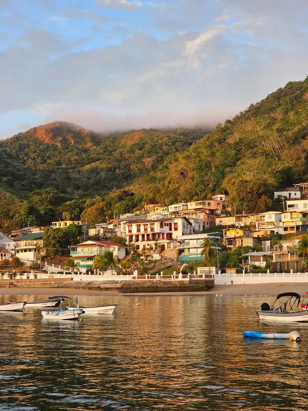 Las casas de colores del pueblo de Taboga suben por la ladera, con lanchas en la orilla