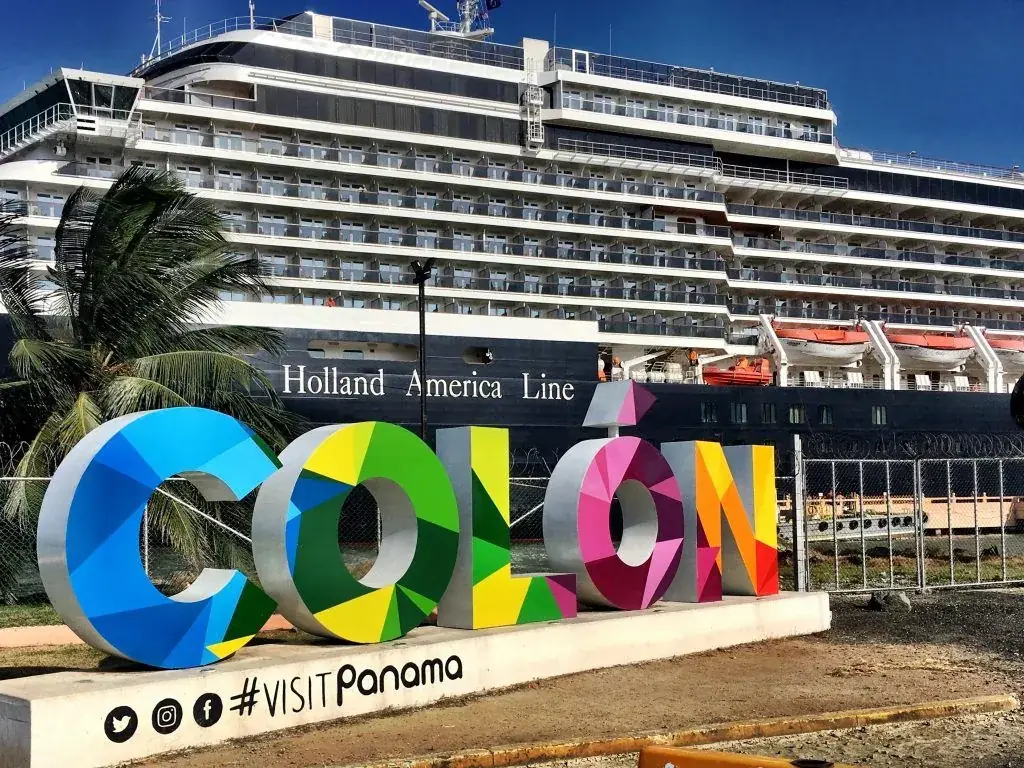 El letrero de colores de Colón, con un crucero atracado detrás