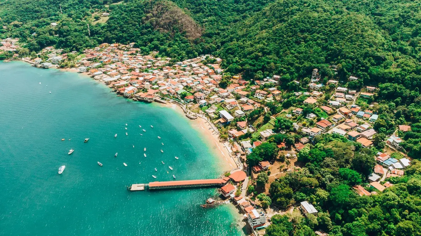 The village of Taboga seen from the air, with its pier and the turquoise bay